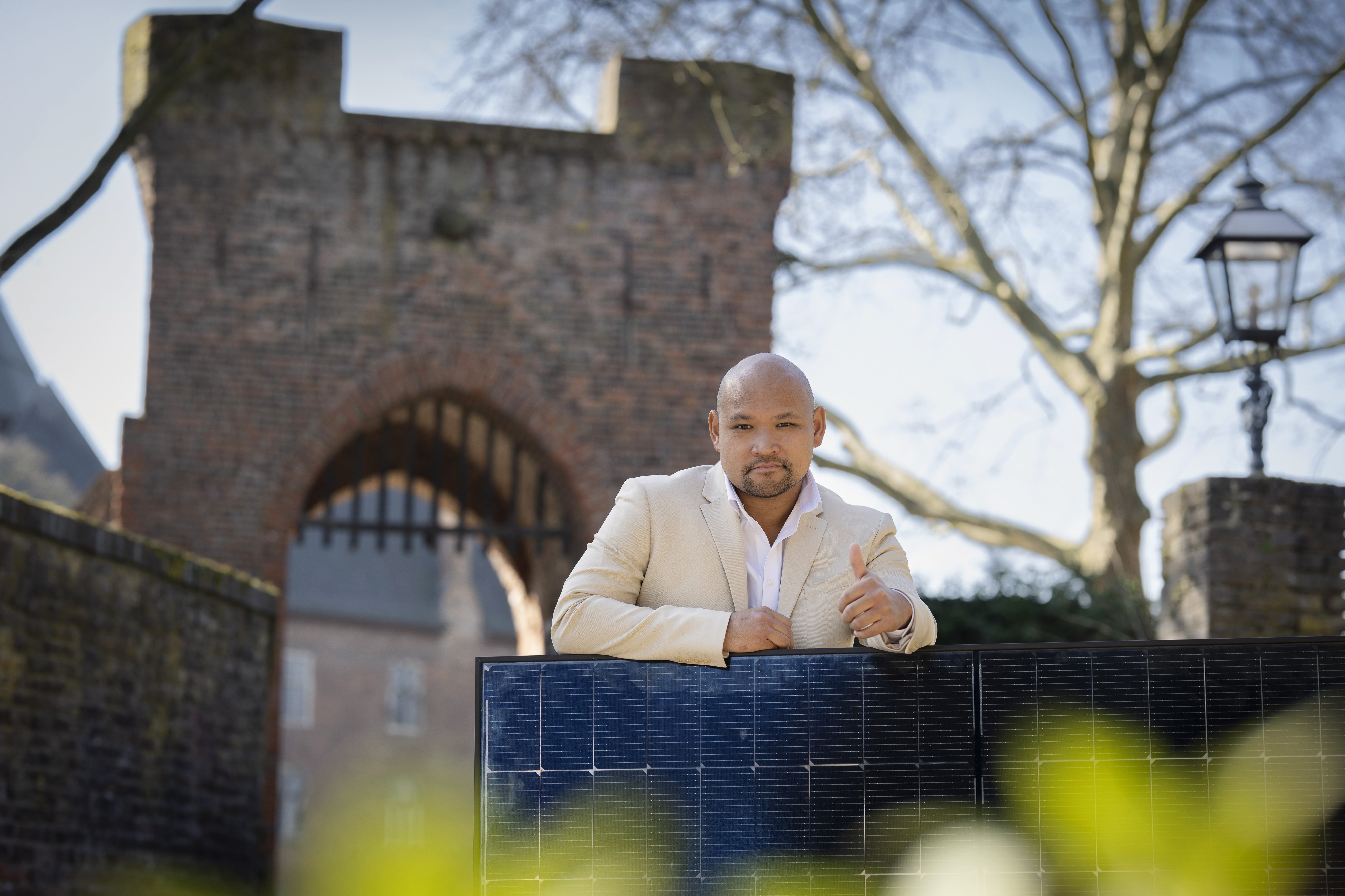 SWK ENERGIE Energieberater Phillip Dinh vor der Burg Linn mit einem PV-Panel