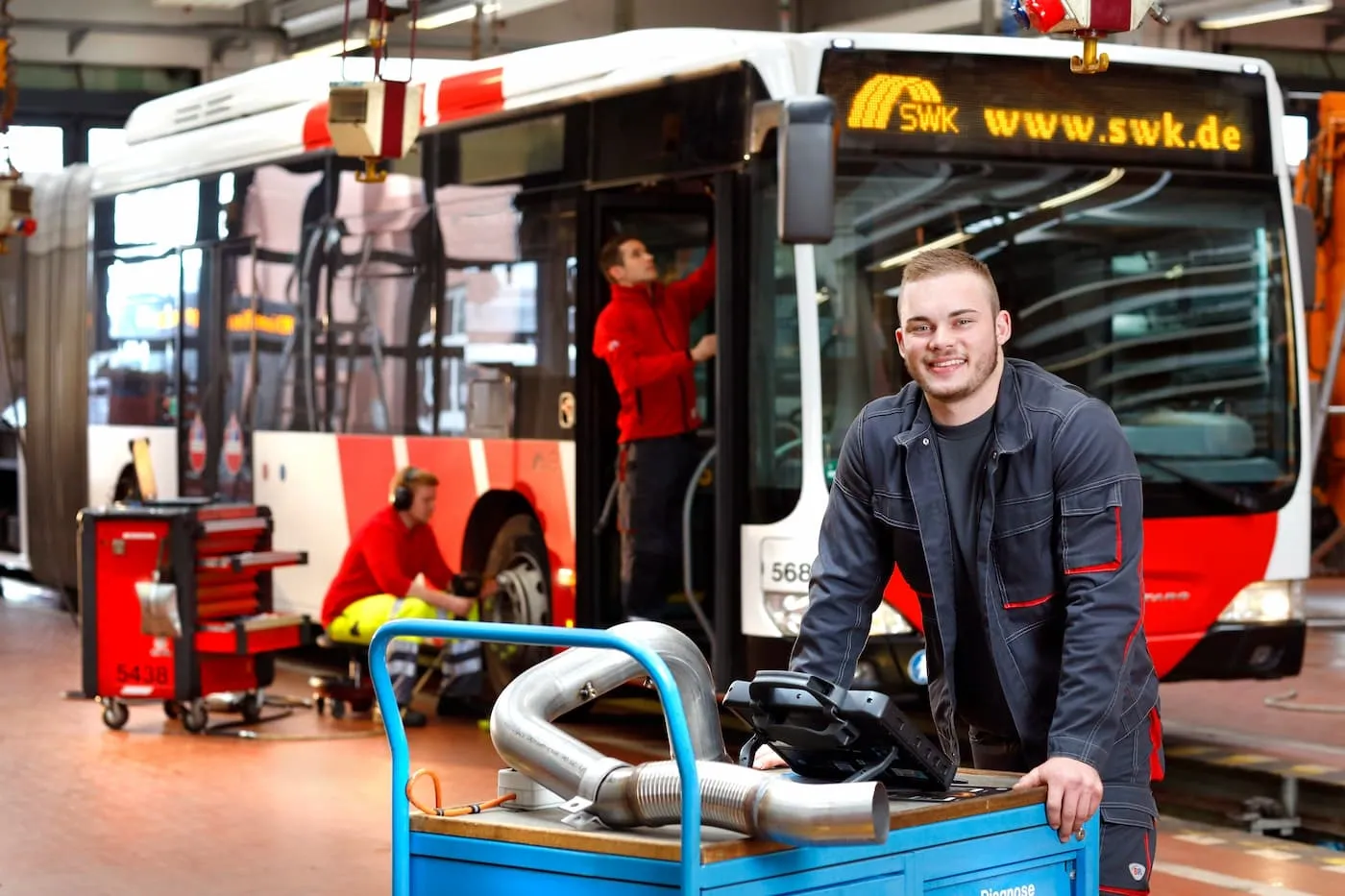 MOBIL Kollege an Diagnosewagen lehnend
