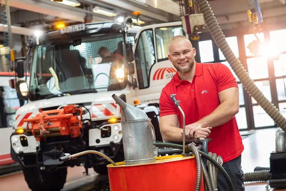Kollege an Ölfass gelehnt vor Sonder-LKW