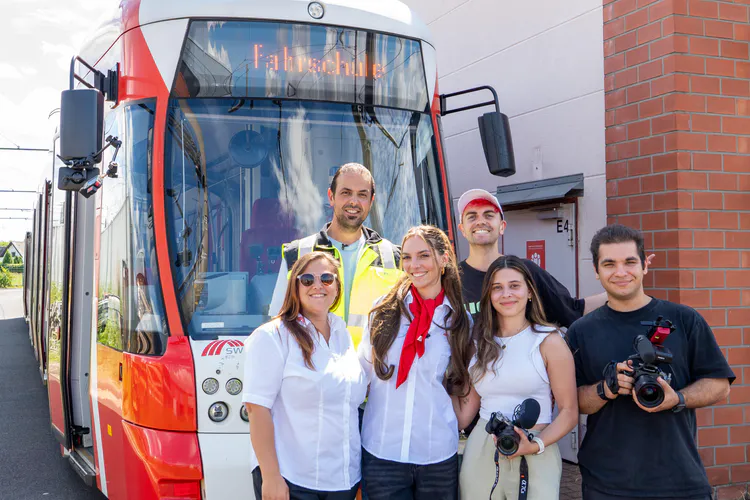 Katharina Xenia mit ihrer Beyond Limits Crew und 2 SWK MOBIL Mitarbeiter*innen vor Straßenbahn