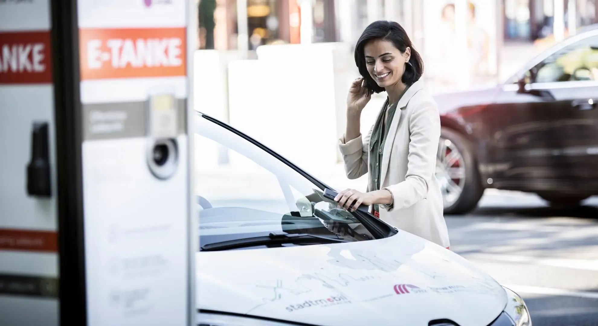 Junge Frau meldet sich mit dem Smartphone beim CarSharing an