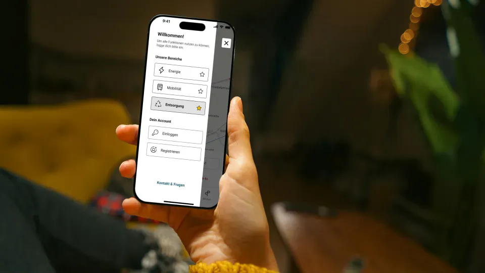 GSAK Person hält Smartphone in der Hand und schaut sich die SWK App an