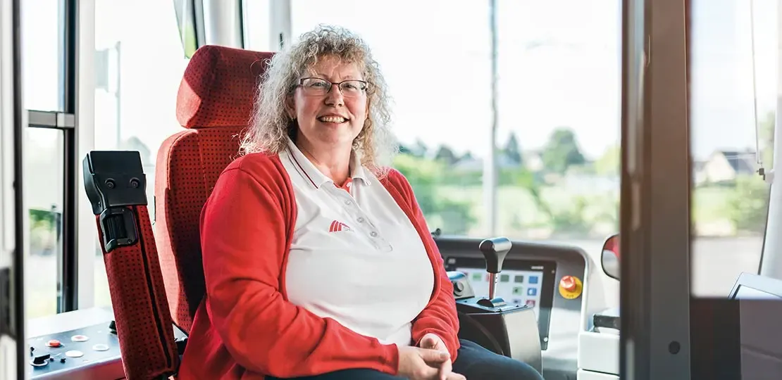 Blonde Busfahrerin sitzt im Bus am Steuer
