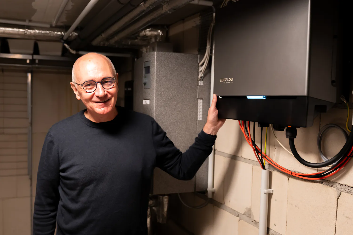 Martin Jentsch, hier neben dem Wechselrichter und Batteriespeicher seiner PV-Anlage, ist rundum glücklich mit seiner Entscheidung.