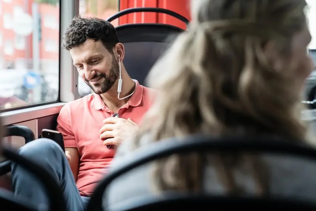 Mann mit Smartphone im Bus