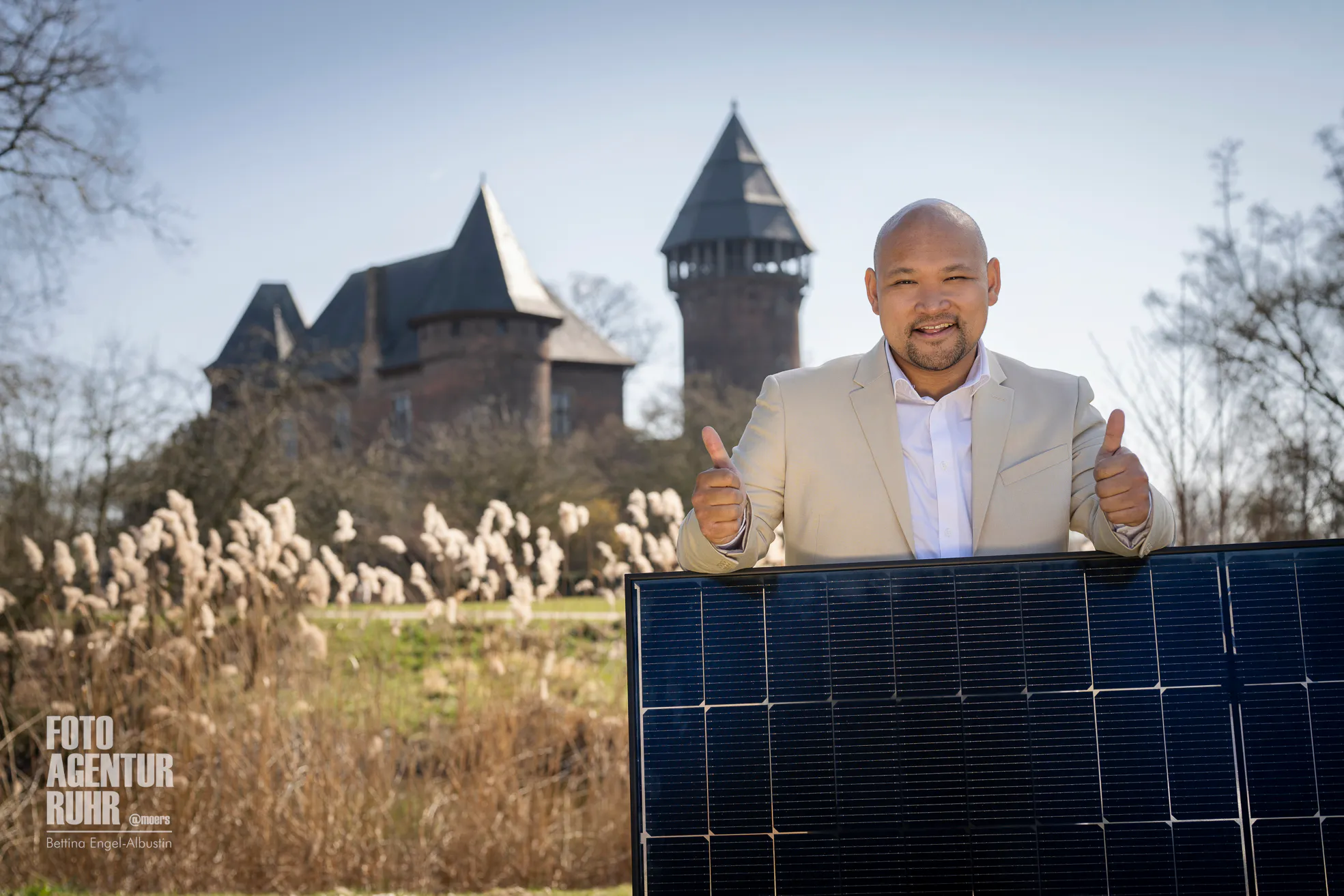 SWK ENERGIE E-Scout Philipp Dinh mit Solarmodul vor der Burg Linn