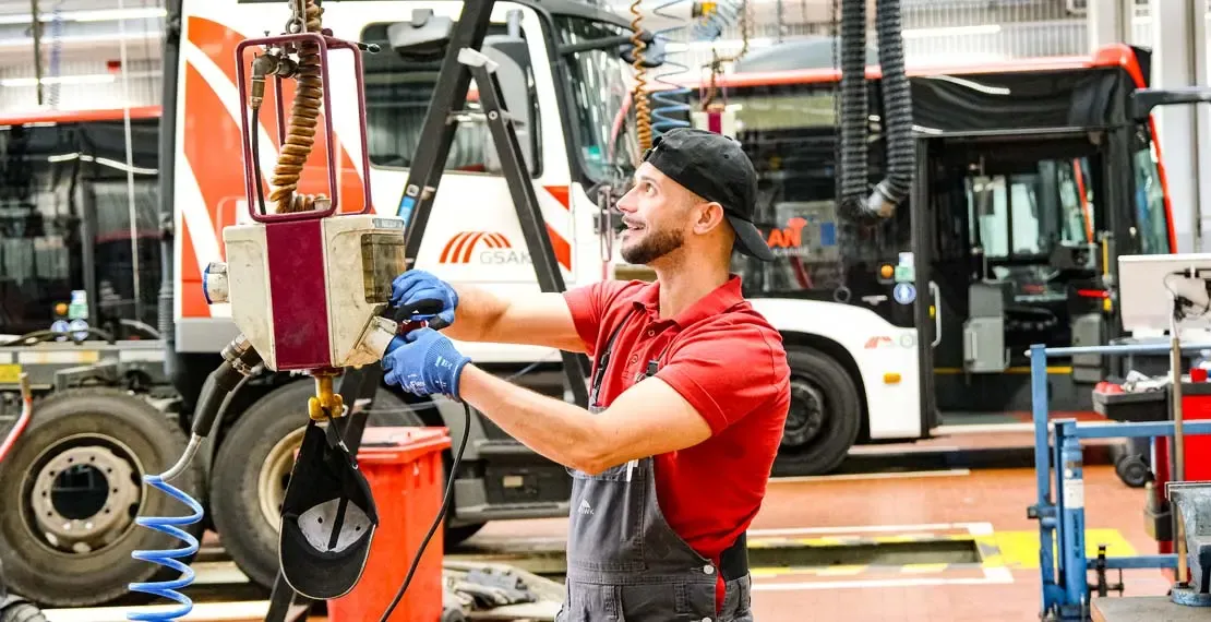 Mitarbeiter Fahrzeugwerkstatt an der Hebebühne