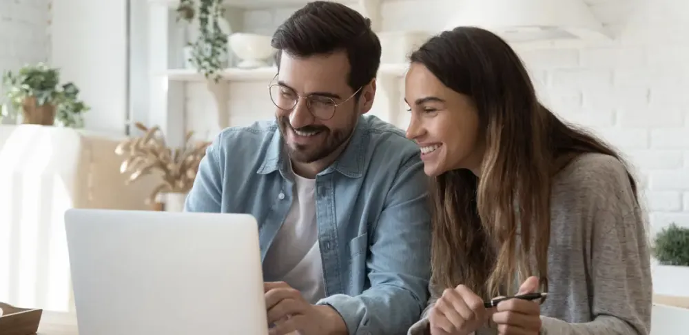 Mann und Frau sitzen vor dem Laptop