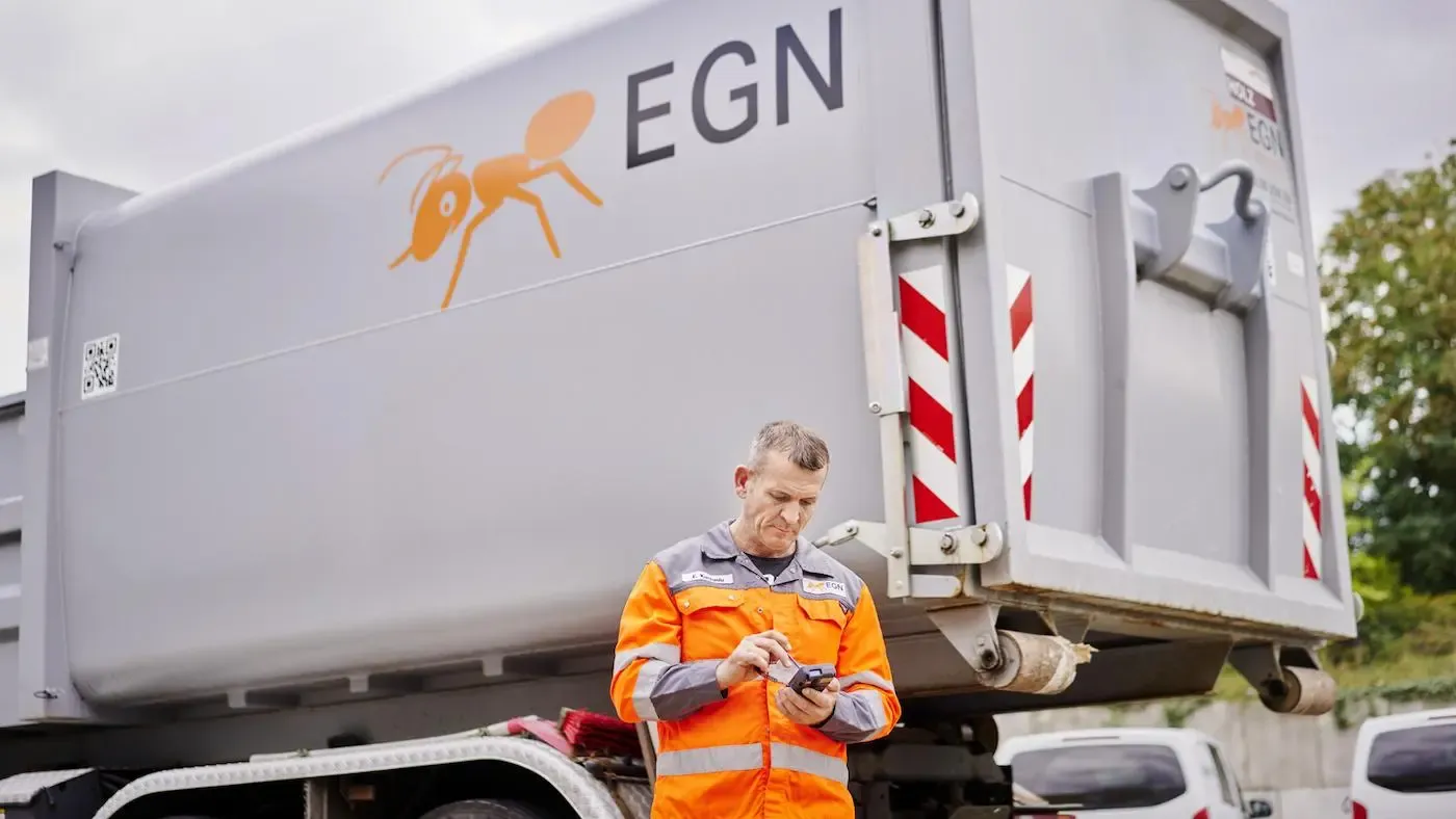 EGN Mitarbeiter steht neben einem EGN Fahrzeug