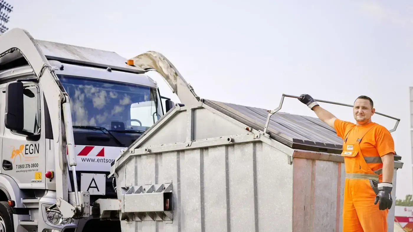 EGN Mitarbeiter in Arbeitskleidung steht vor einem Container