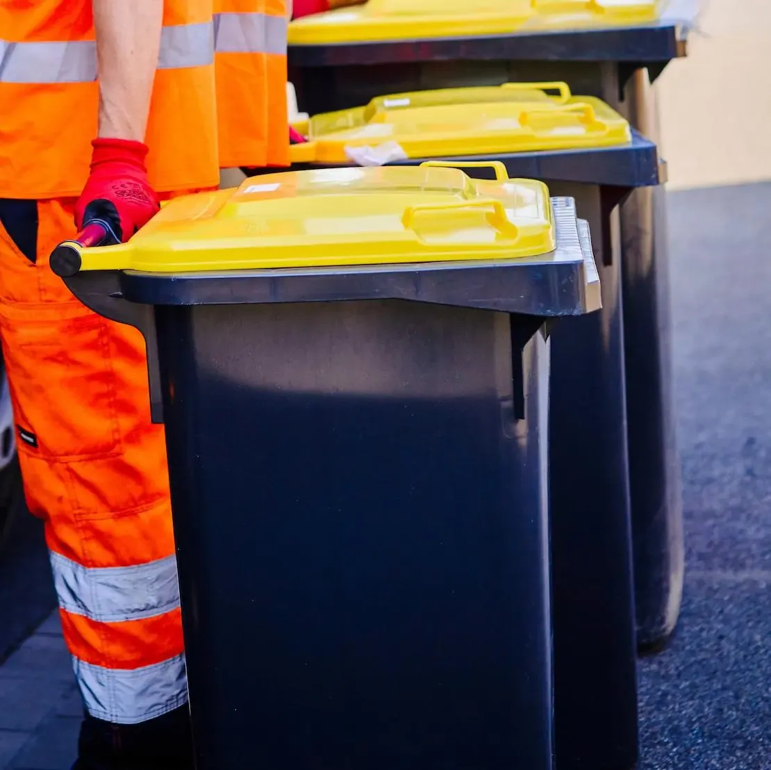 Müllwerker der EGN mit einer gelben Tonne