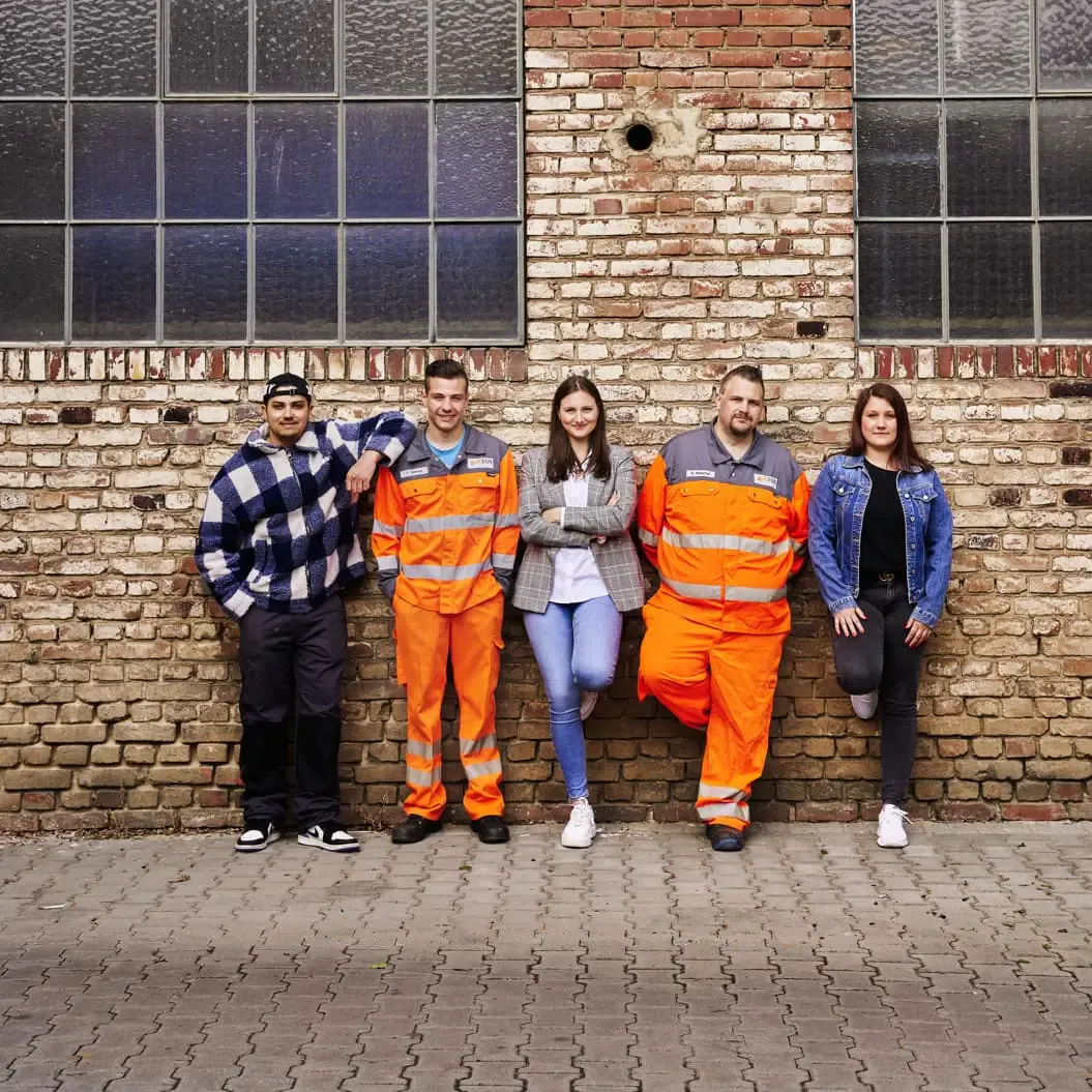 Azubis der EGN stehen vor einer Häuserwand