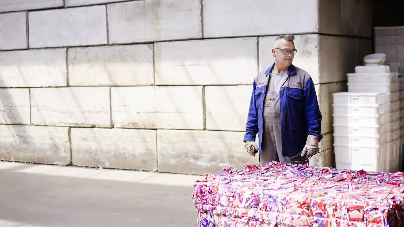 Mitarbeiter der EGN Entsorgungsgesellschaft Niederrhein steht vor einem Block mit recyceltem Material