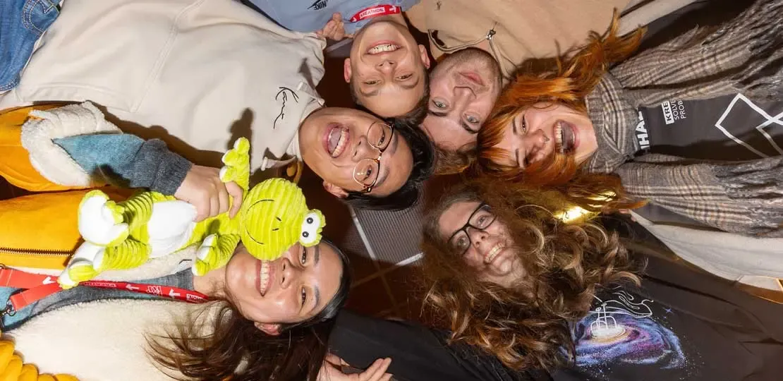 Gruppe von jungen Leuten stecken die Köpfe im Kreis zusammen