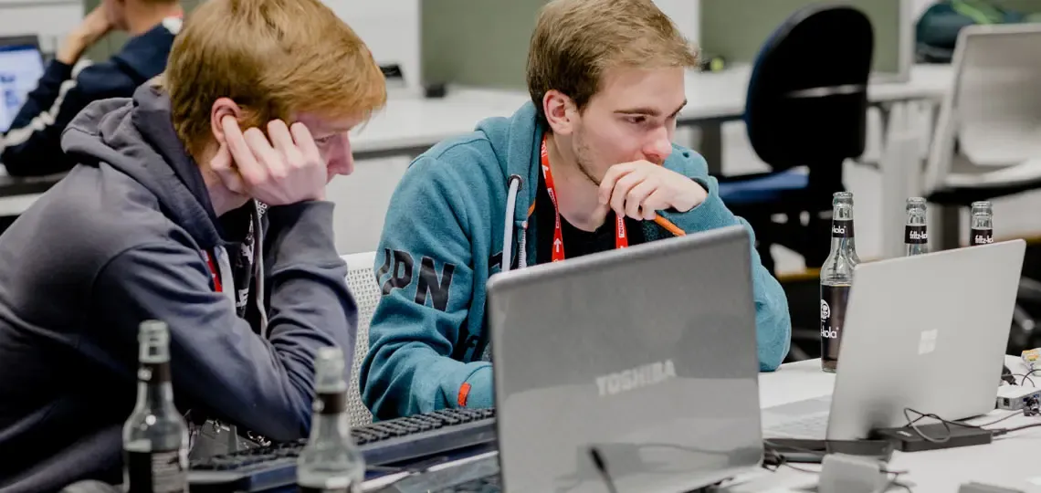 Zwei KReathon Teilnehmer sitzen vor ihrem Laptop