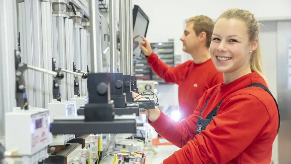 NGN Kollegin in rotem Pullover lächelt in die Kamera