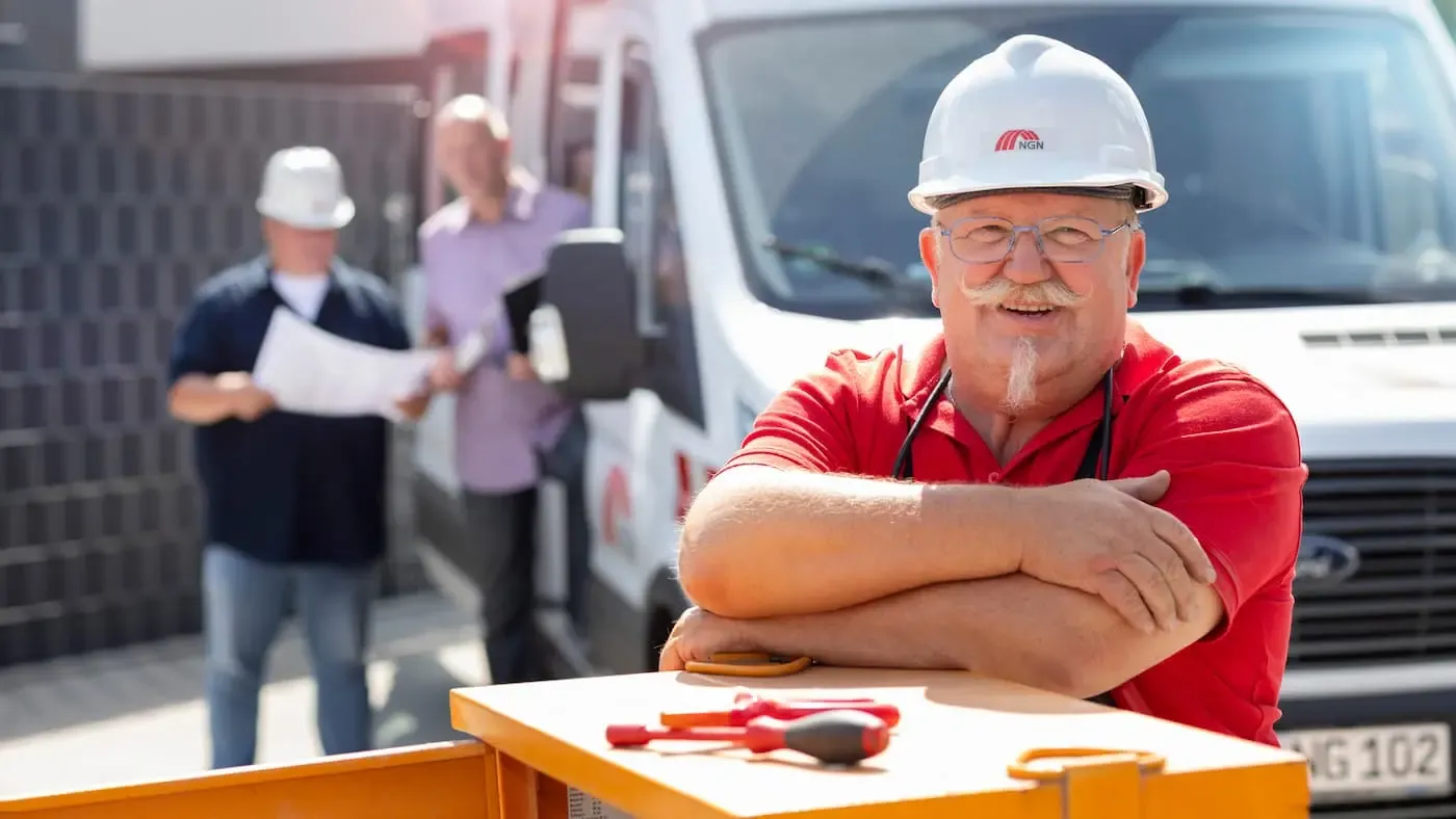 NGN Kontakt Mitarbeiter mit Helm lächelt in die Kamera