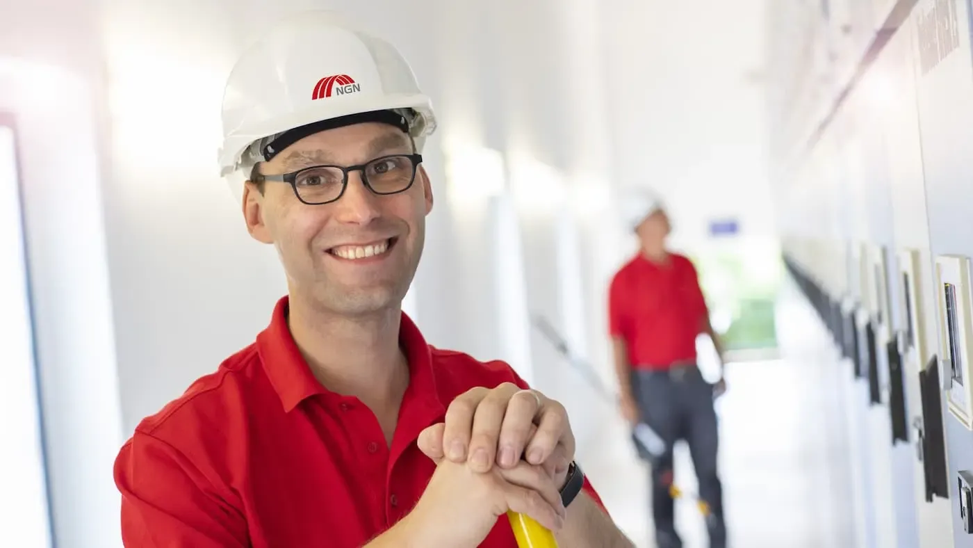 NGN Mitarbeiter mit Helm lächelt in die Kamera