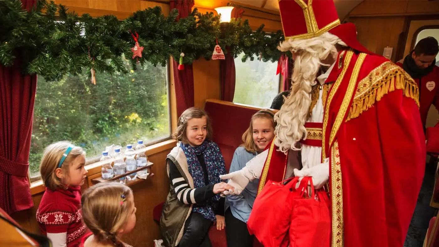 Der Nikolaus übergibt Kindern Geschenke während der Nikolausfahrt im Schluff Krefeld