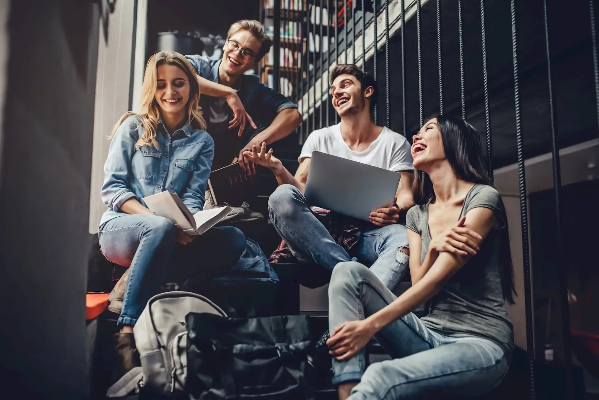 Studierende sitzen auf einer Treppe und unterhalten sich