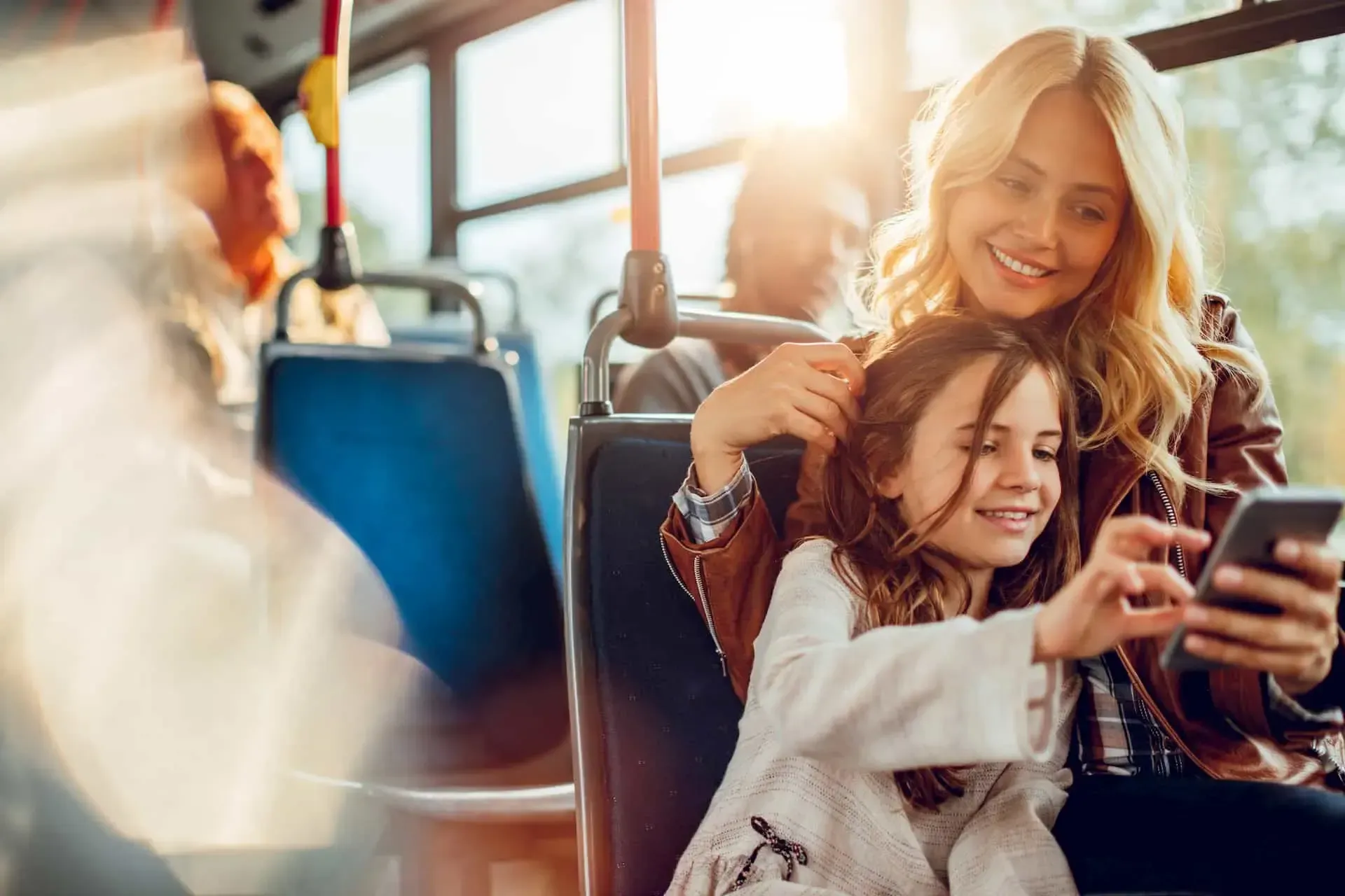 Frau sitzt mit Kind in einem Bus