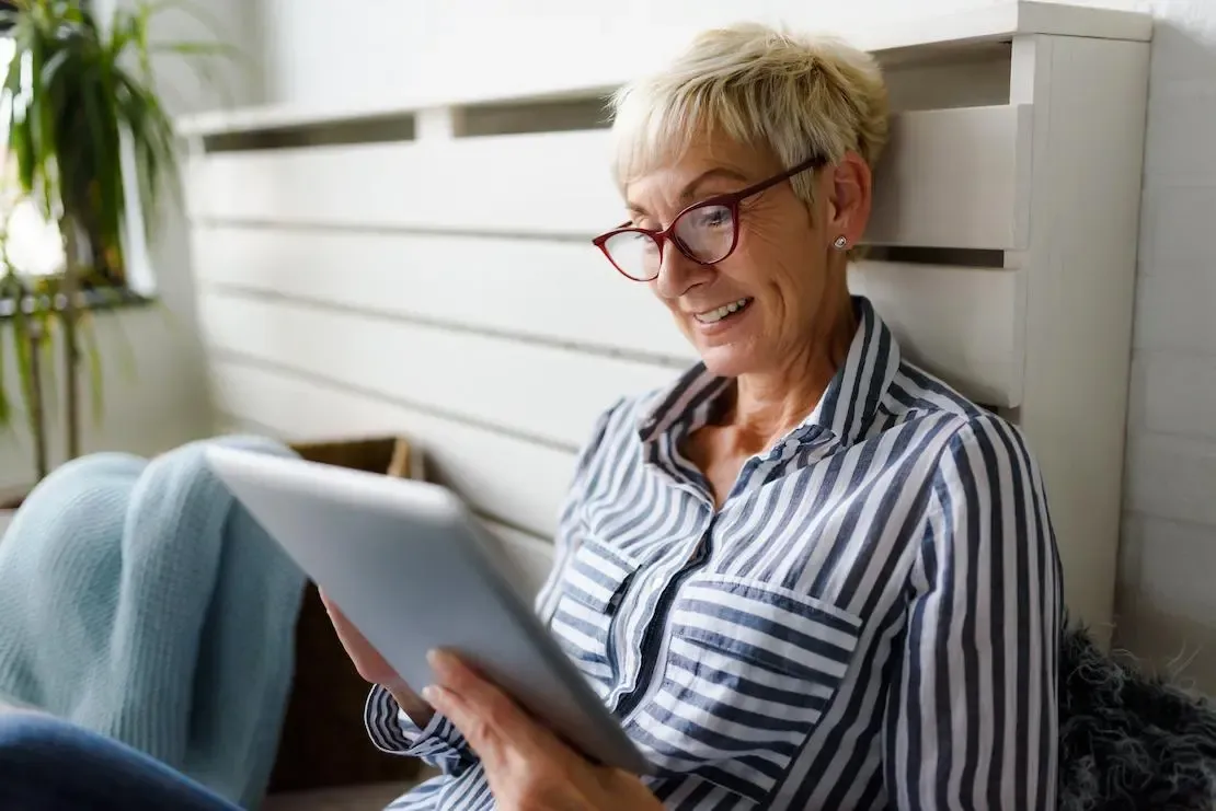 Ältere Dame mit Tablet in der Hand