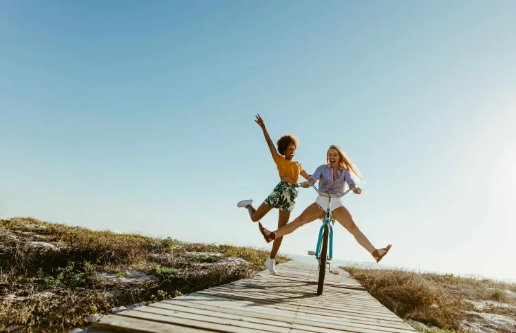 Zwei Frauen springen am Strand in die Luft