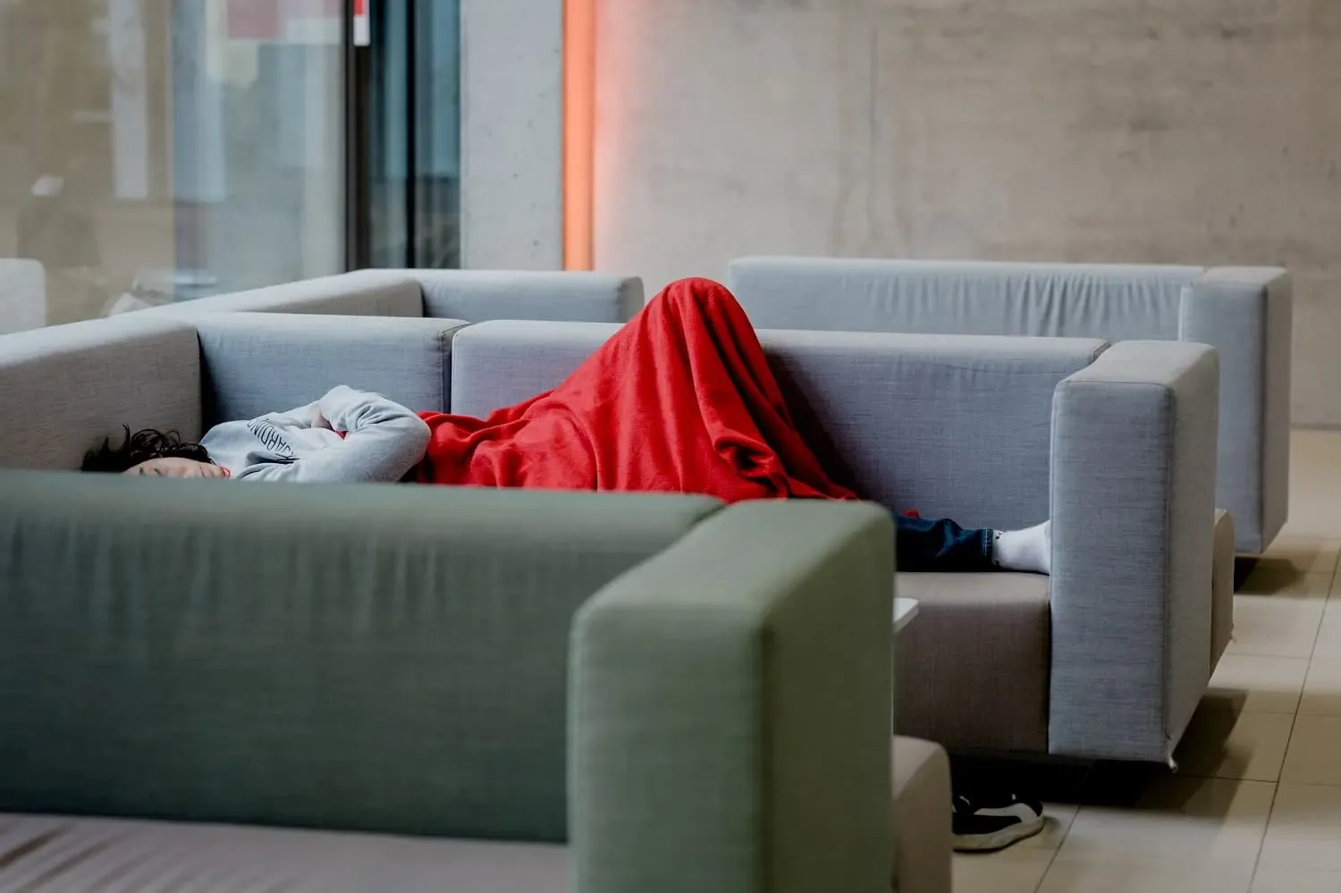 KReathon Teilnehmer schläft mit einer roten Decke auf dem Sofa
