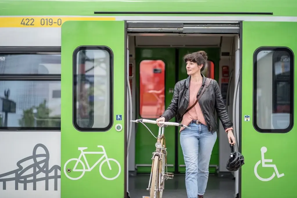Junge Frau schiebt Fahrrad aus der Bahn
