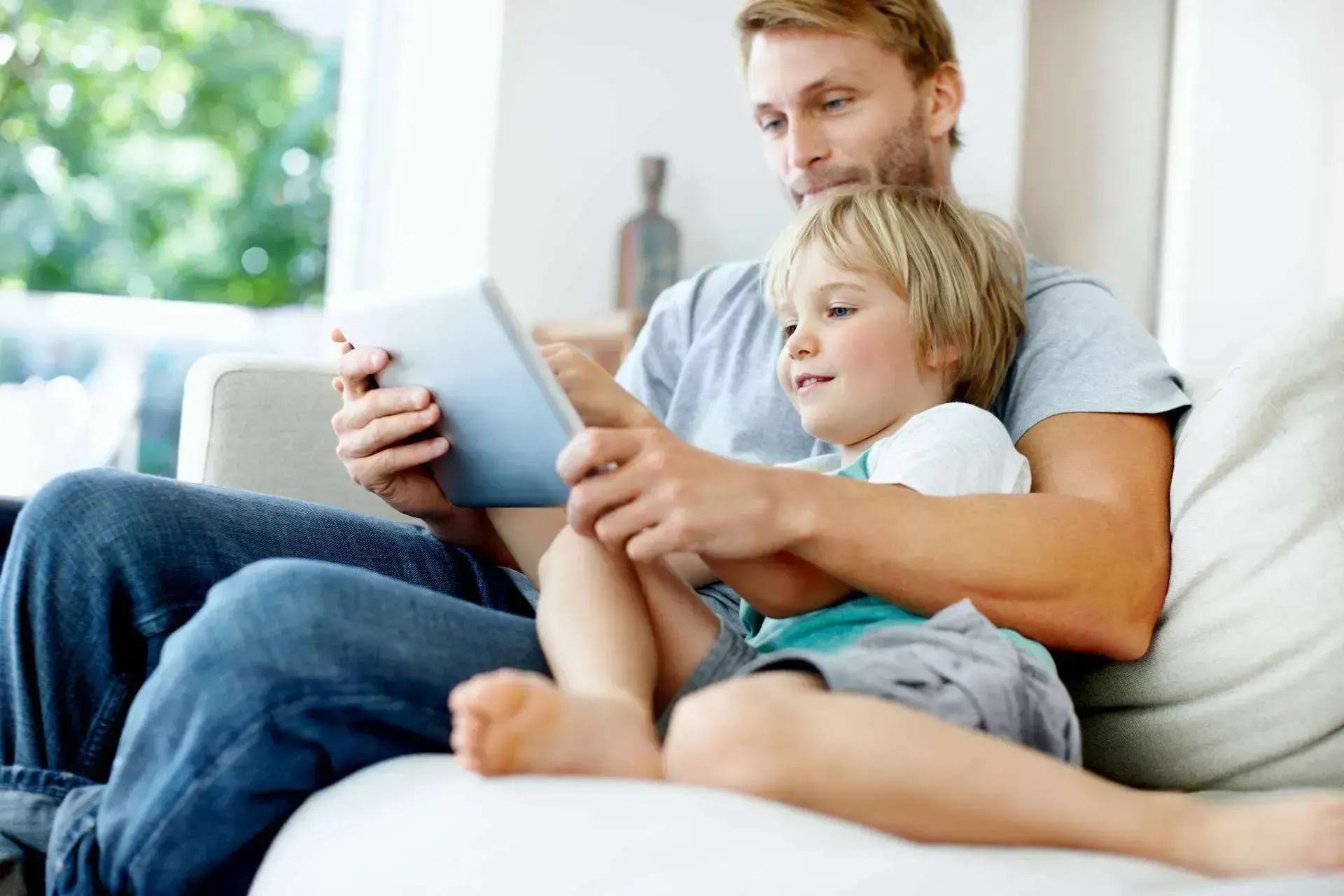 Vater und Sohn surfen auf dem Tablet im Service Bereich der SWK Homepage