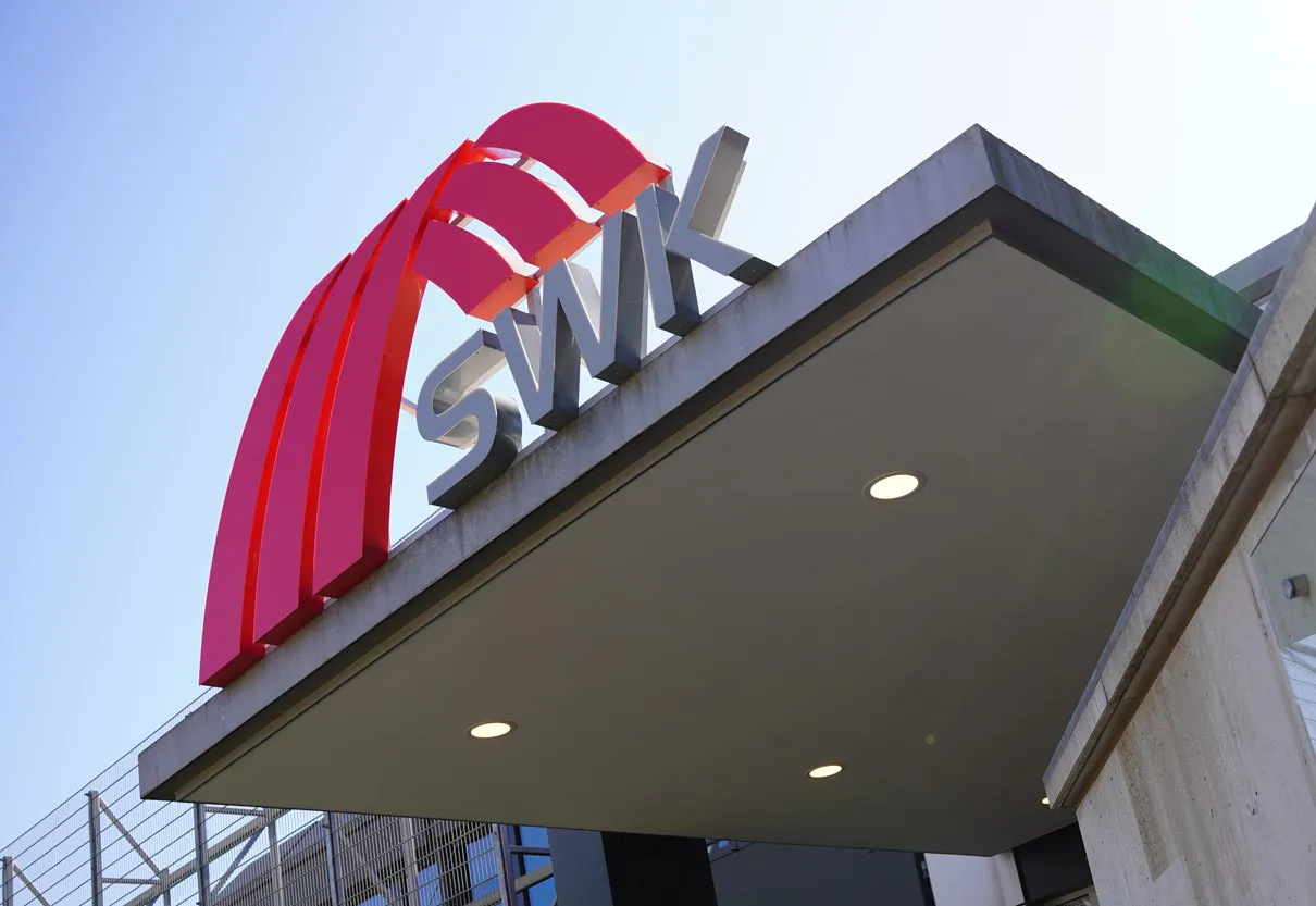 Großes SWK-Logo im Sonnenschein vor der SWK-Zentrale