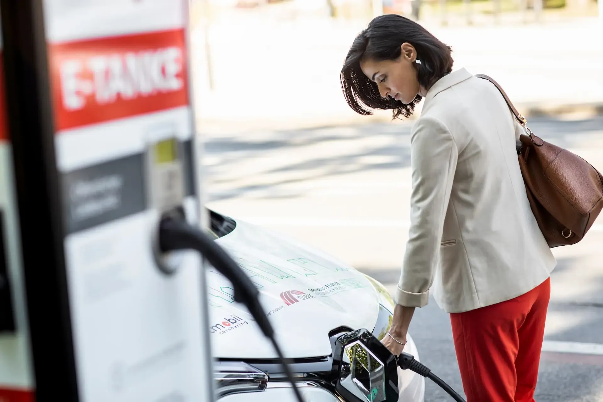 Frau lädt ihr Auto an einer Ladestation