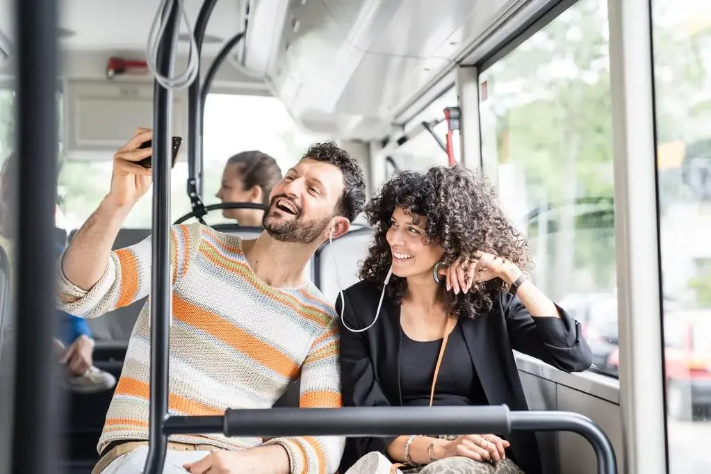 Mann und Frau fotografieren sich im Bus
