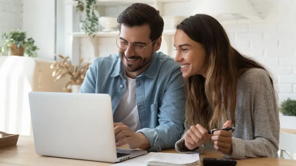 Mann und Frau sitzen vor dem Laptop