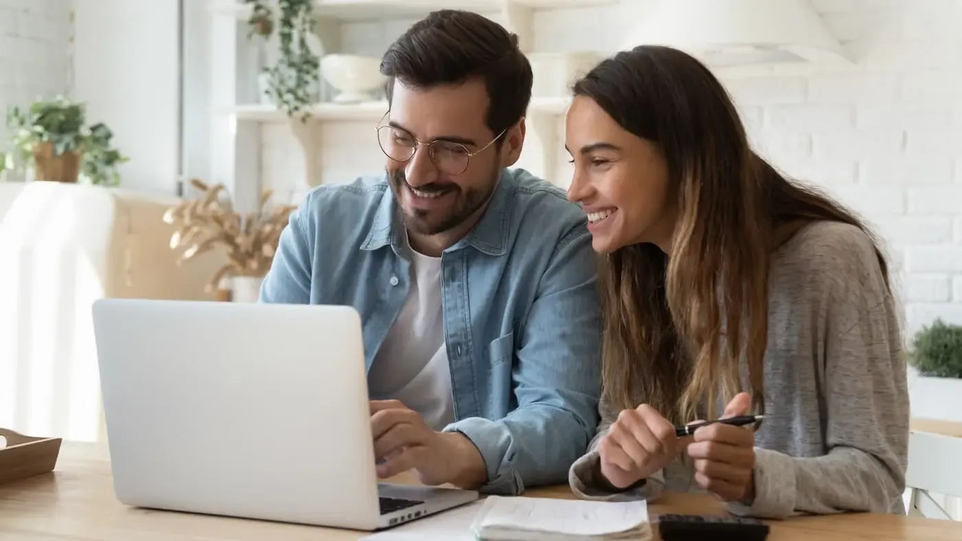 Mann und Frau sitzen vor dem Laptop