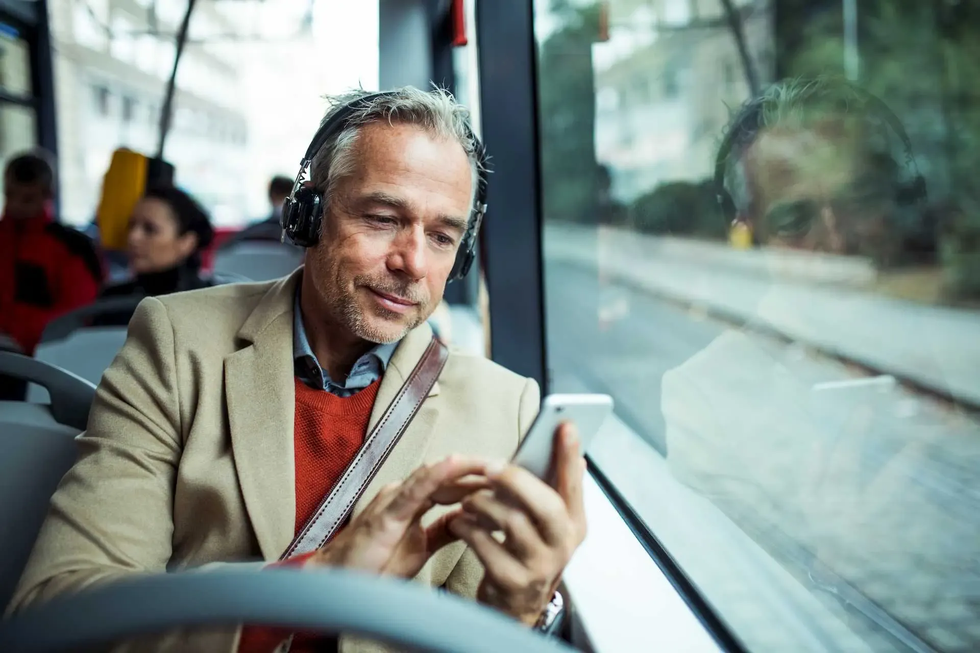 Mann mit Smartphone in der Hand im ÖPNV