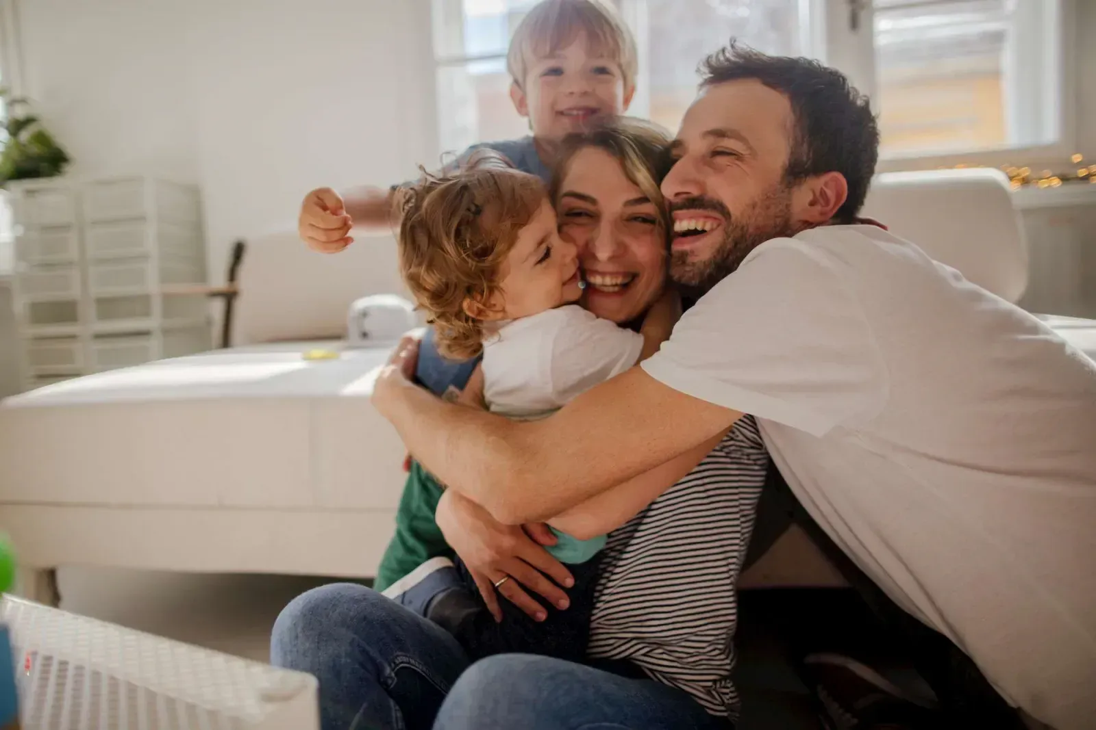 Vierköpfige Familie umarmt sich