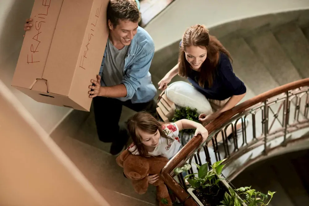 Familie mit Umzugskartons im Treppenhaus