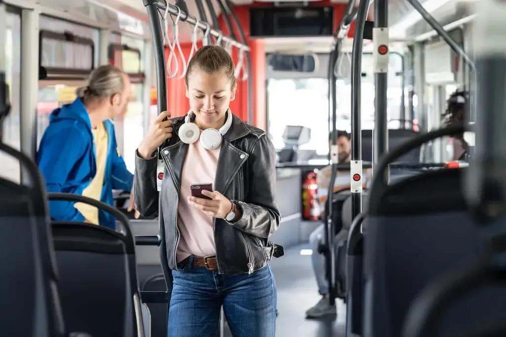 Junge Frau mit Smartphone im Bus