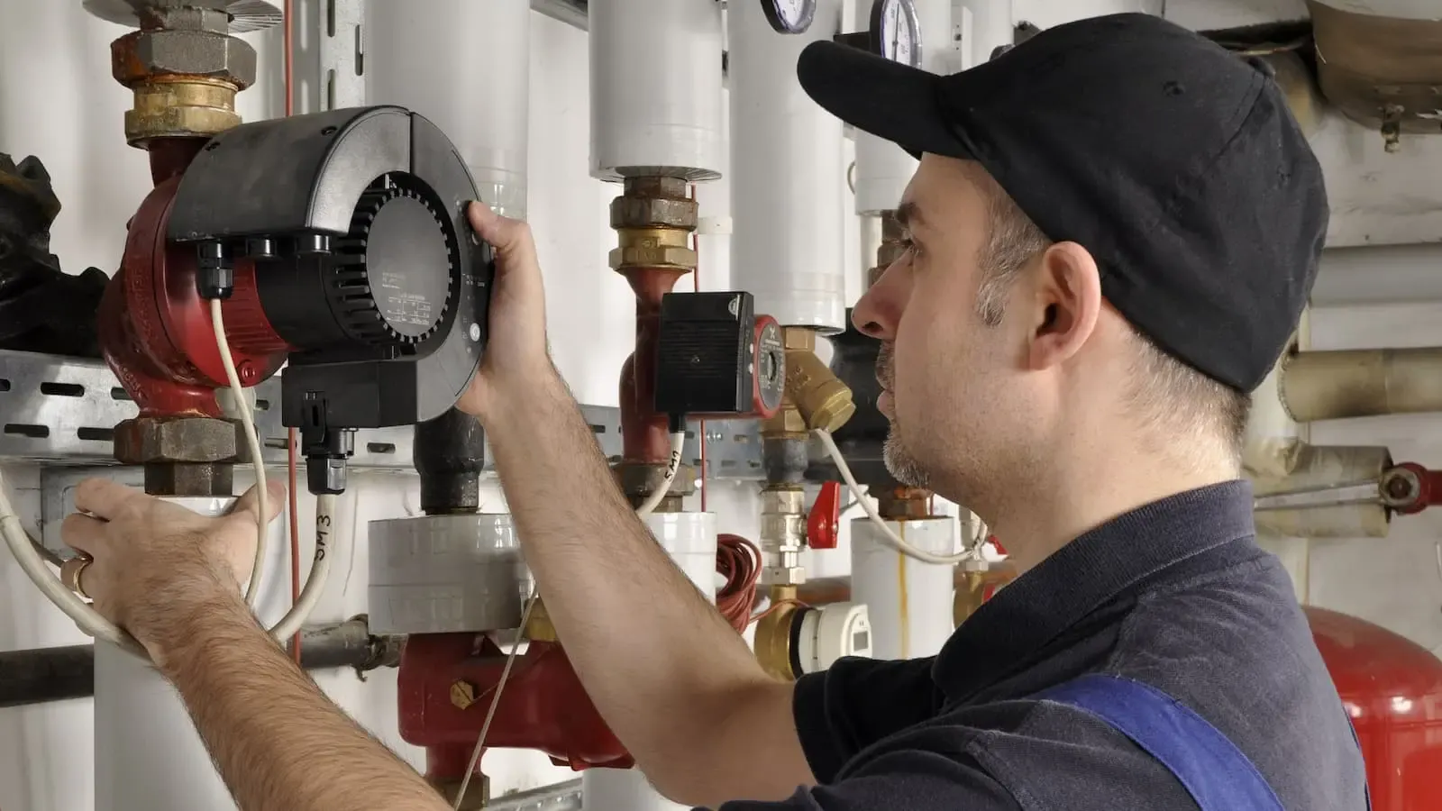 Mann arbeitet an einer Heizung