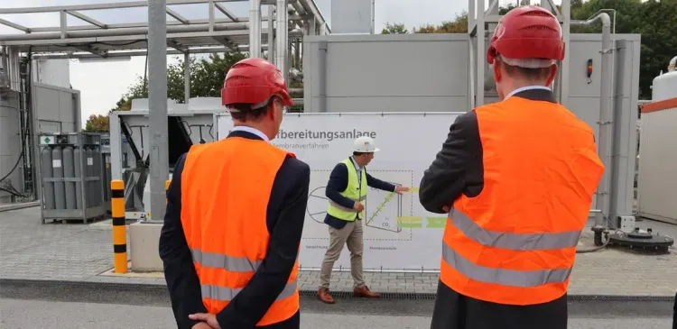 Zwei Personen vor der Biogasaufbereitungsanlage