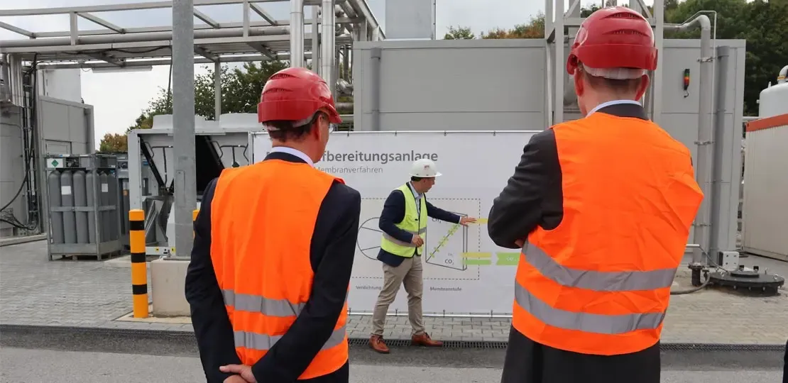 Zwei Personen vor der Biogasaufbereitungsanlage