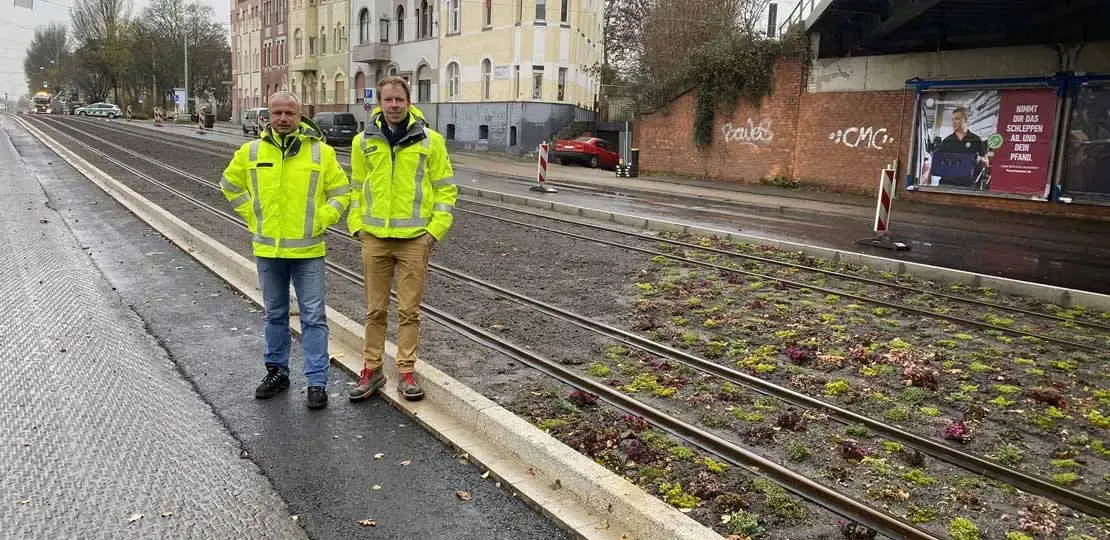 Dirk Sommerfeld und Marcel Krins in Warnjacken auf Straßenbahnschienen