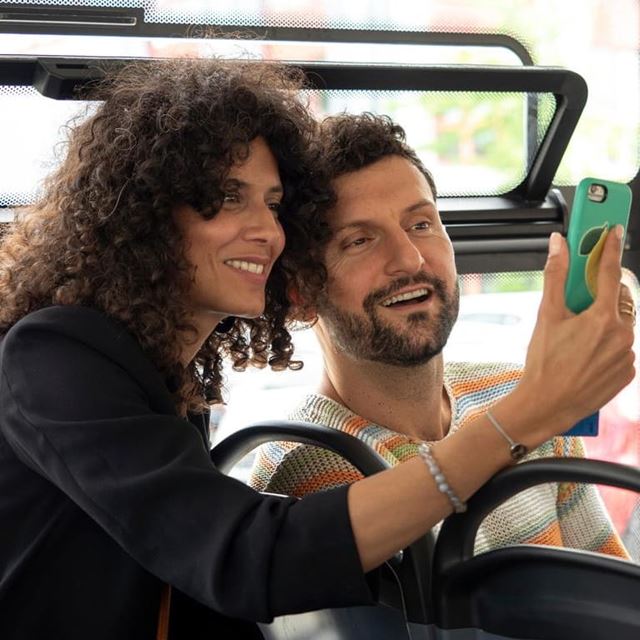 Paar sitzt im Bus und guckt auf Smartphone