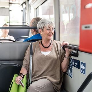 Rentnerin sitzt im Bus und guckt aus dem Fenster